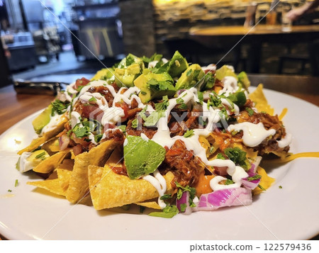 Vibrant Nachos with Avocado and Pulled Meat Close-Up View Vibrant Nachos with Avocado and Pulled Meat Close-Up View 122579436