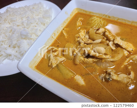 Thai Chicken Curry with Rice in Warm Dining Setting Eye-Level View Thai Chicken Curry with Rice in Warm Dining Setting Eye-Level View 122579460