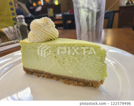 Key Lime Cheesecake Close-Up in Cozy Restaurant Setting 122579496