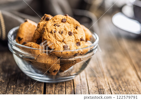 Chocolate chip cookies in bowl on wooden table. Chocolate chip cookies in bowl on wooden table. 122579791