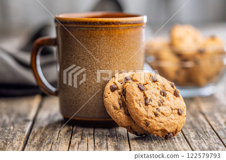 Chocolate chip cookies and mug on wooden table. Chocolate chip cookies and mug on wooden table. 122579793