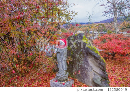 A cute Jizo statue surrounded by autumn leaves at their best. 122580949