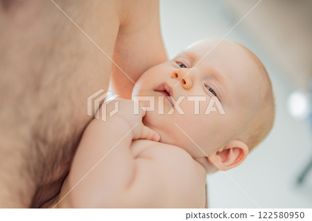 A baby peacefully falls asleep in his father's arms, skin-to-skin. A heartwarming and intimate moment of love, bonding, and parenthood, showcasing the deep connection between father and child A baby peacefully falls asleep in his father's arms, skin-to-skin. A heartwarming and intimate moment of love, bonding, and parenthood, showcasing the deep connection between father and child 122580950