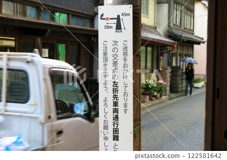 觀光區一條狹窄的住宅道路上豎立著一塊警示車輛無法通行的標誌牌。 122581642