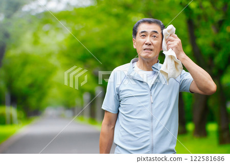 Smiling senior man wiping sweat off in the park Smiling senior man wiping sweat off in the park 122581686