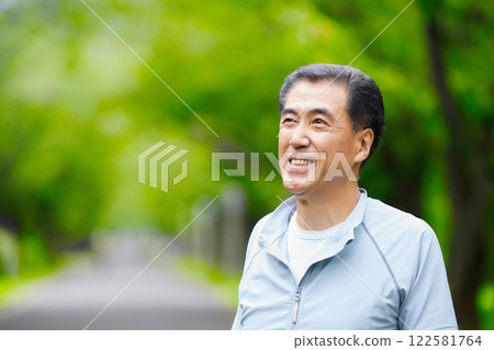 微笑的老人站在公園的綠樹上 122581764