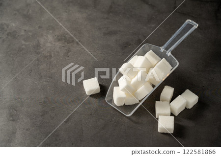 White sugar cubes and canned sugar in a white bowls, dark background. Sugar addiction concept 122581866