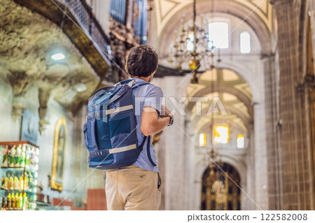Male tourist exploring the Metropolitan Cathedral in Mexico City. Woman admiring the architecture and history of Mexico's iconic landmark. Concept of cultural heritage, religious tourism, and travel Male tourist exploring the Metropolitan Cathedral in Mexico City. Woman admiring the architecture and history of Mexico's iconic landmark. Concept of cultural heritage, religious tourism, and travel 122582008