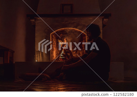 Family bonding by the fireplace during cozy winter evening. Warm and peaceful family moment indoors. Togetherness, love, and relaxation concept. A warm and inviting scene featuring a lit fireplace Family bonding by the fireplace during cozy winter evening. Warm and peaceful family moment indoors. Togetherness, love, and relaxation concept. A warm and inviting scene featuring a lit fireplace 122582180