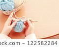 Hands crocheting light blue yarn 122582284