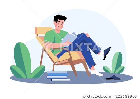 Young Man Sits In An Armchair And Reads A Book Young Man Sits In An Armchair And Reads A Book 122582916