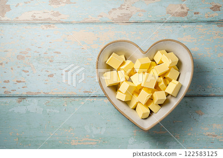 Butter cubes grass-feed butter slices in a heart shaped bowl. Vitamin D and source of fat, copy space 122583125