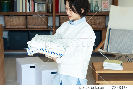 Woman folding clothes Woman folding clothes 122583281