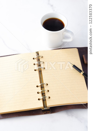 An image of working at a desk with a ring-type notebook open while drinking freshly brewed coffee. An image of working at a desk with a ring-type notebook open while drinking freshly brewed coffee. 122583370