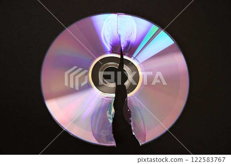 Broken optical disk on a black background 122583767