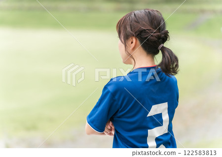 A woman in a uniform watching soccer A woman in a uniform watching soccer 122583813