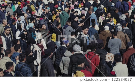 Large crowd gathering and protesting in a public square 122584057