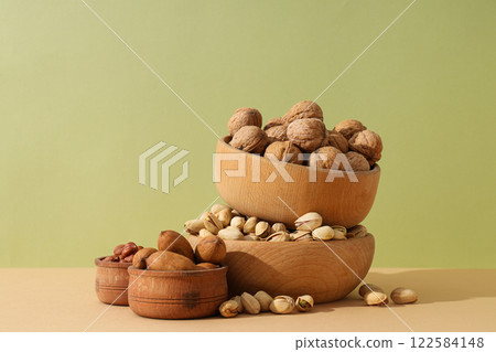 Various nuts in wooden bowls on a light background 122584148
