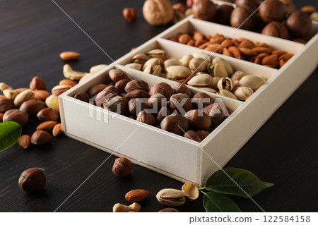 Wooden box with different nuts on a dark background 122584158
