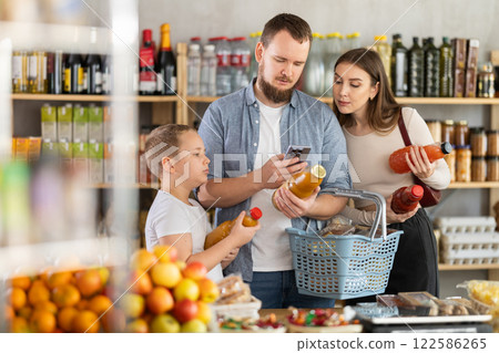 Family scanning barcodes on juice bottles in grocery store 122586265