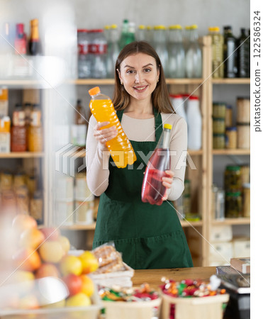 Girl stands near counter in grocery department of store, gesturing to look at assortment 122586324