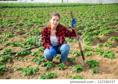 Portrait of young attractive female farmer with hoe Portrait of young attractive female farmer with hoe 122586337