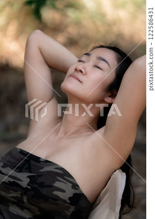 Portrait of sexy asian woman in a military print strapless dress, camping in the forest concept. 122586431
