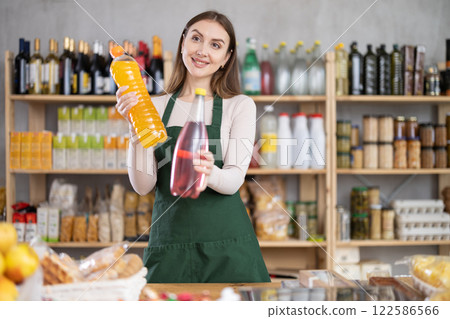 Girl stands near counter in grocery department of store, gesturing to look at assortment 122586566