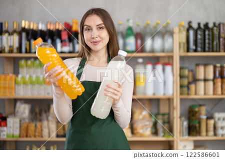 Young woman seller offering soda in grocery store 122586601
