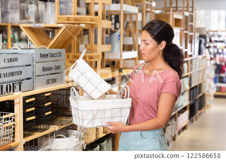 Asian female standing with basket in shop Asian female standing with basket in shop 122586658