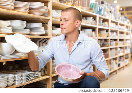 Man choosing plates in store Man choosing plates in store 122586759