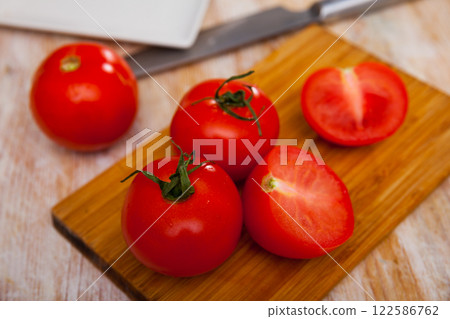 Fresh organic tomatoes on wooden kitchen table Fresh organic tomatoes on wooden kitchen table 122586762