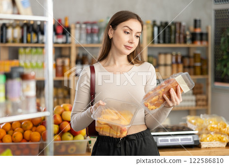 Young girl is choosing chicken in grocery store Young girl is choosing chicken in grocery store 122586810