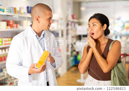 Woman with toothache asks the pharmacist what medicine to buy Woman with toothache asks the pharmacist what medicine to buy 122586821