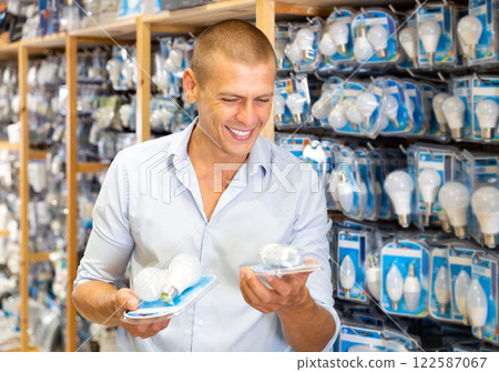 Man choosing energy saving light bulbs 122587067