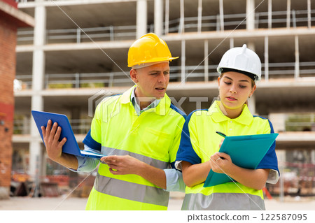 Two architects with laptop discussing construction plan Two architects with laptop discussing construction plan 122587095