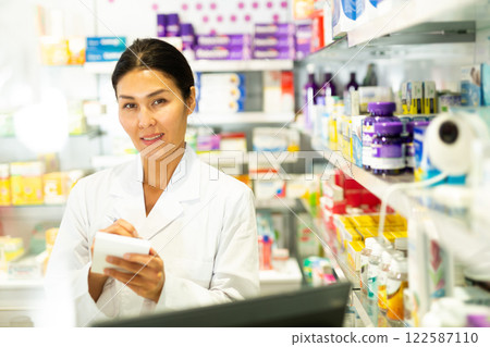 Female pharmacist working in pharmacy, using computer screen Female pharmacist working in pharmacy, using computer screen 122587110