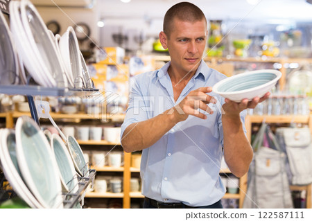 Man buyer choosing dishes at decor store 122587111