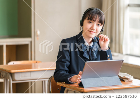 身穿制服的國中和高中女生用平板電腦學習（線上英語對話） 122587530