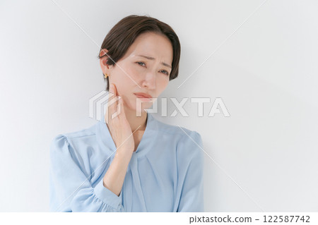 Middle-aged woman with hands on face Middle-aged woman with hands on face 122587742