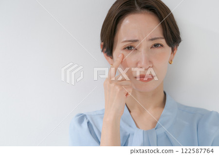 Middle-aged woman with hands on face Middle-aged woman with hands on face 122587764