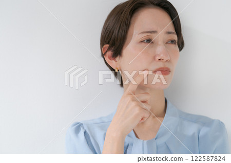 Middle-aged woman with hands on face 122587824