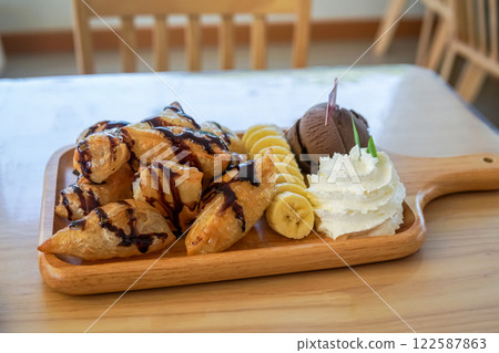 Ice cream chocolate waffle with whipping cream and bananas. 122587863