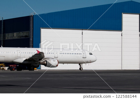 White passenger airplane near the aviation hangar 122588144