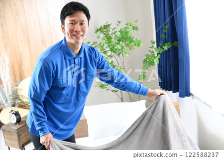 穿著工作服鋪床的亞洲男人 122588237