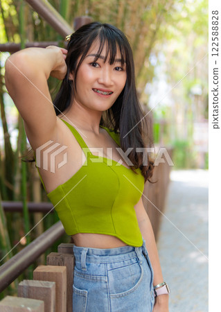 Portrait of beautiful sexy asian woman Wearing a green strapless dress and jean skirt in a cafe 122588828