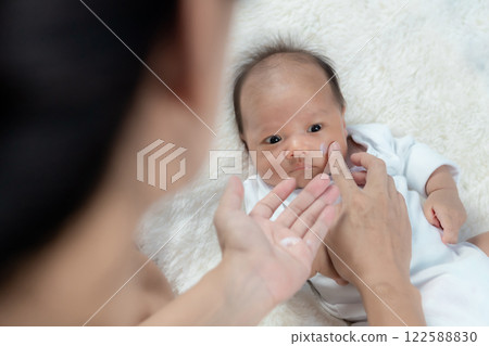 Baby applying cream to face with atopic dermatitis Baby applying cream to face with atopic dermatitis 122588830