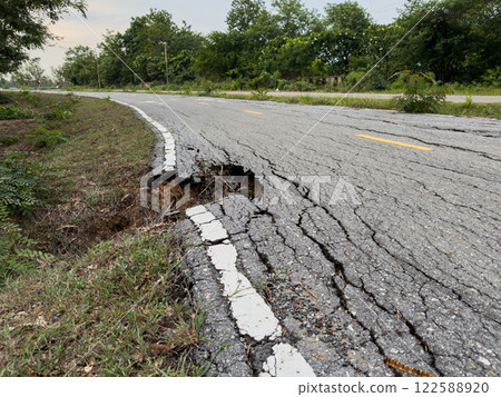 The road used for jogging in the park is damaged. 122588920