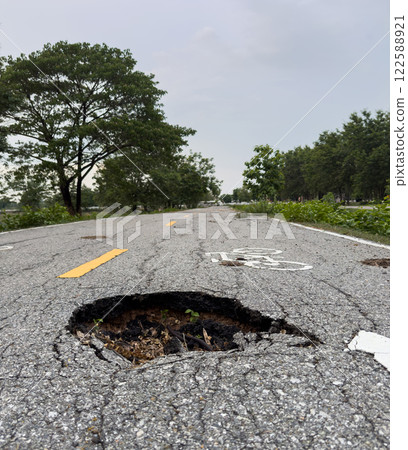 The road used for jogging in the park is damaged. The road used for jogging in the park is damaged. 122588921