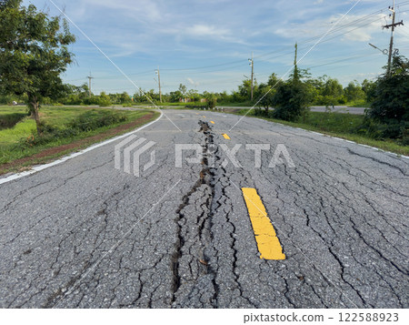 The road used for jogging in the park is damaged. 122588923